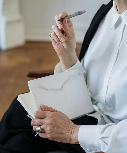 Person holding pen and a diary to note down